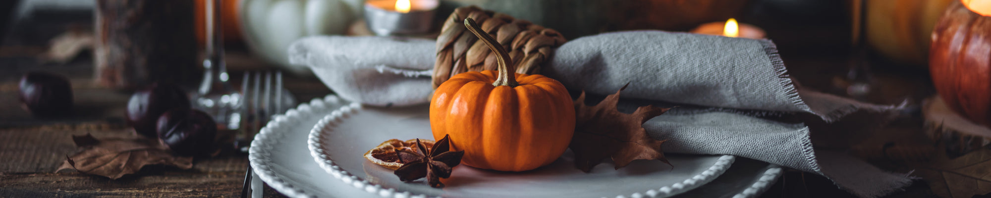 Thanksgiving dinner table setting with pumpkin